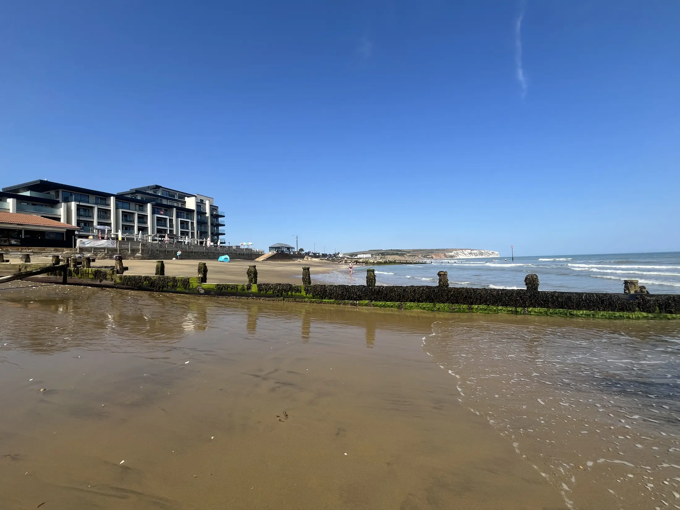 Sandown beach, with the apartment's seafront building at the left and Culver Cliff beyond