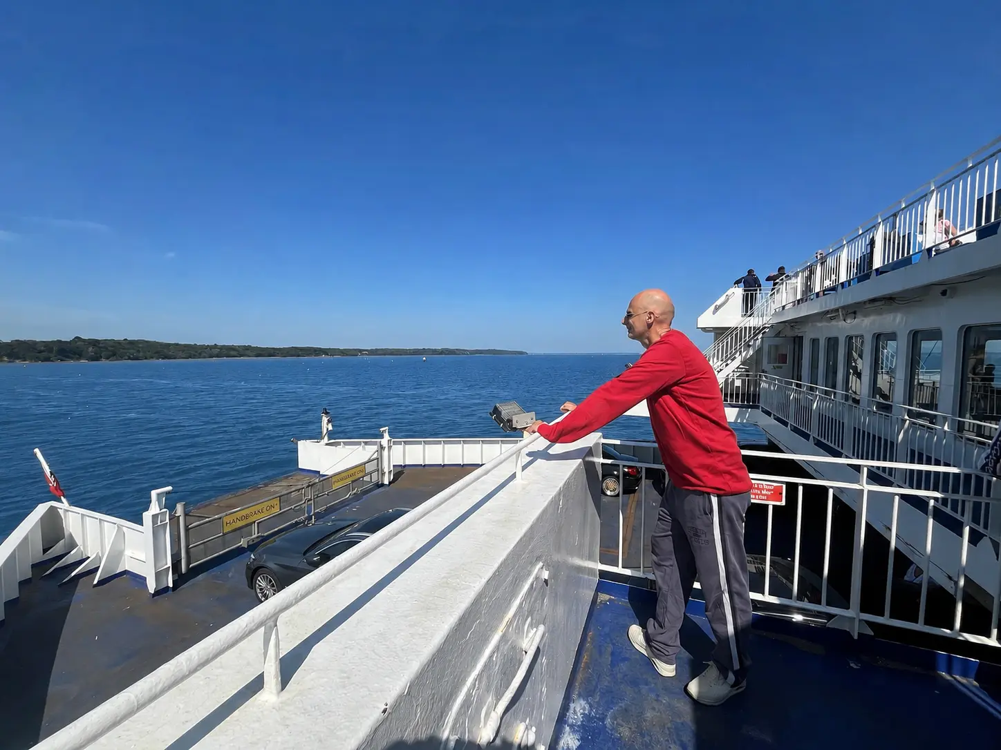 A passenger enjoying the blue sea view from the open deck of the Isle of Wight ferry