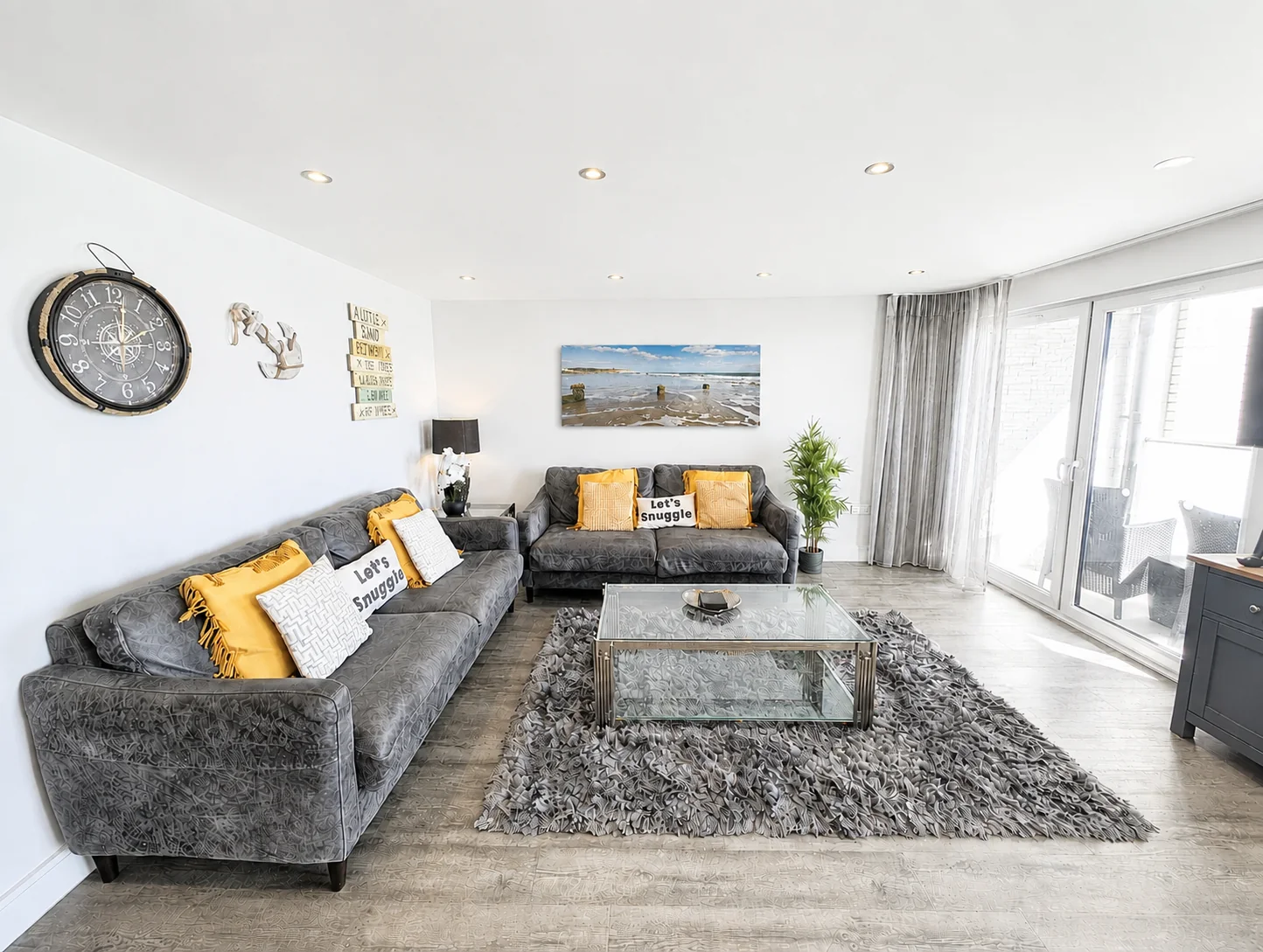 Bright living room with two grey sofas and a large Sandown Bay board print
