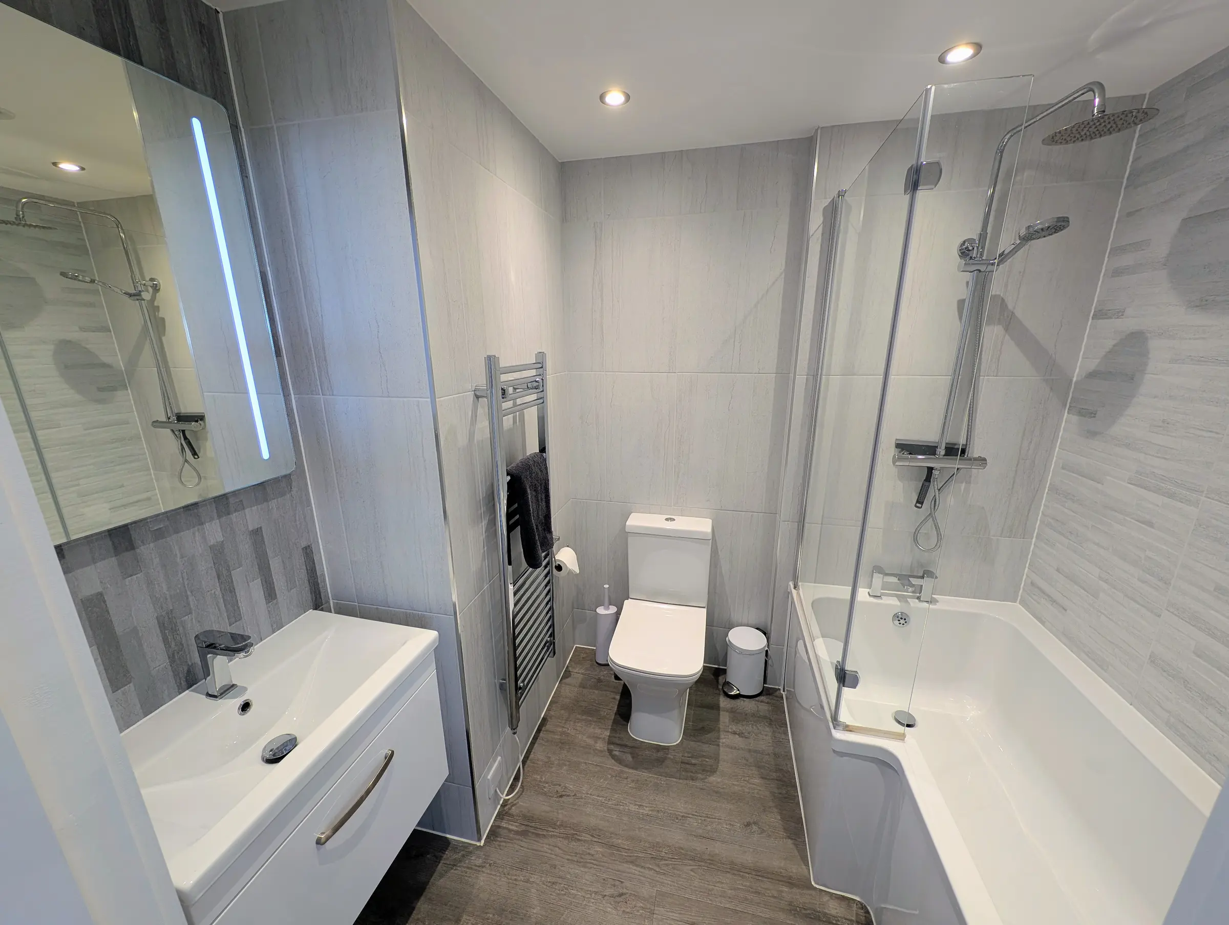 Main bathroom with a bath, rainfall shower, washbasin and toilet